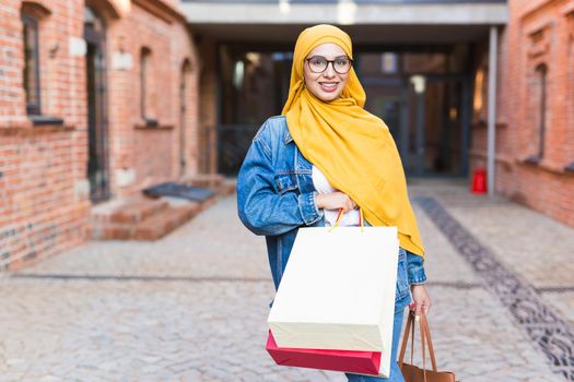 Happy arab muslim girl with shopping bags after mall