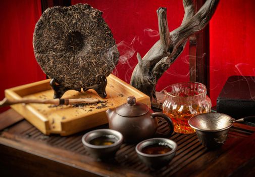 tea table with instruments teapots cups pancake and tea Shen Puer