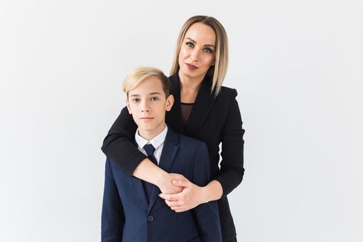 Teenager and single parent - Young mother and son standing together on white background