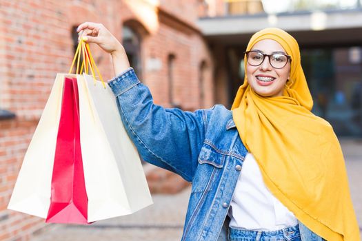 Happy arab muslim girl with shopping bags after mall