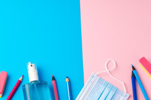 School stationery items and medical face mask, top view