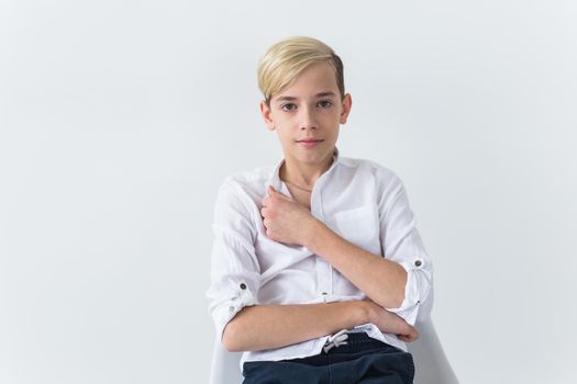 Solitude, loneliness and boredom concept - Bored teen student sitting in a school chair isolated on white