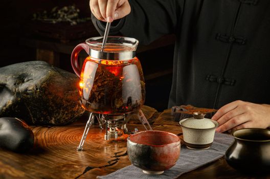 the tea ceremony brewing tea on fire in a glass teapot