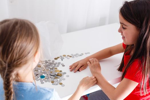 portrait of little girls sitting at table and calculating money