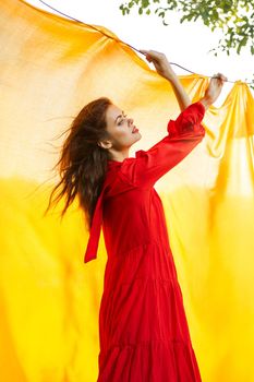 festively outdoors yellow cloth on the background of posing red dress. High quality photo