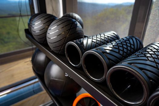 Balls and foam roller sport equipment in a gym on shelf