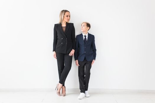 Teenager and single parent - Young mother and son standing together on white background