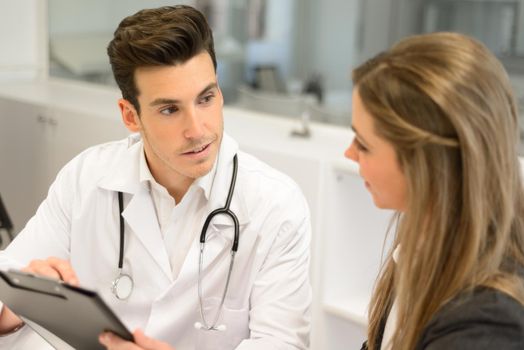 Portrait of a doctor listening to patient explaining her painful in his office