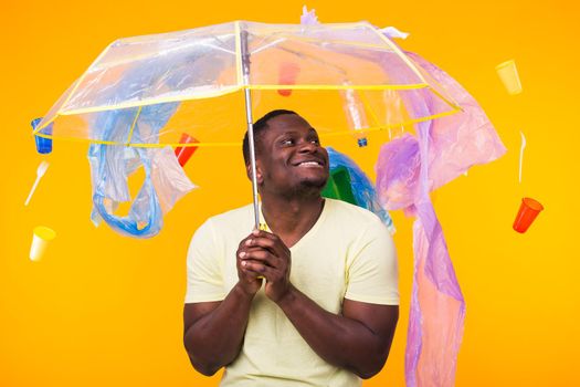 World Environment Day, plastic recycling problem and environmental disaster concept - Surprised african american man looking on trash on yellow.