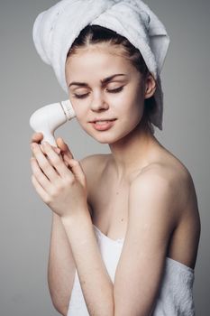 woman with towel on head facial massager skin care hygiene. High quality photo