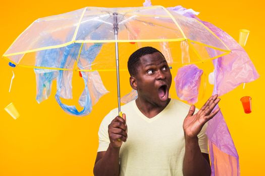 World Environment Day, plastic recycling problem and environmental disaster concept - Terrified man on yellow background with trash.