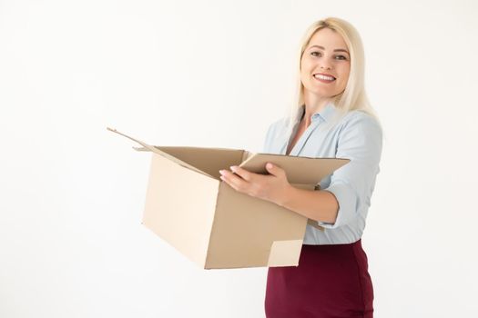 A young beautiful caucasian woman holding a box in her hands.