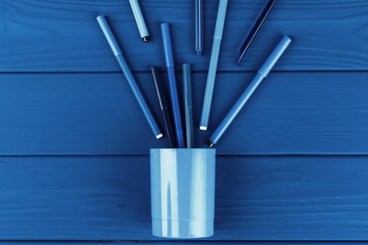 Classic blue colored top view photo of scattered stationery. Close up.