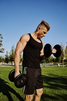 sports male park workout fitness exercise dumbbells. High quality photo