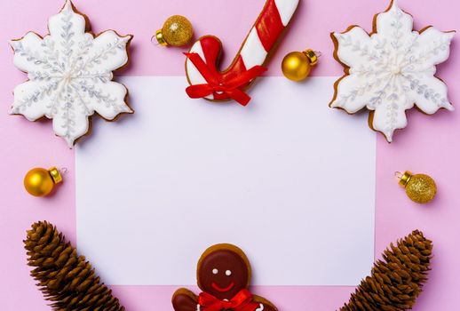 Mock up of holiday greeting card with gingerbread cookies on pink background, view from above