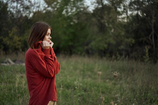 woman outdoors in a red sweater cool nature. High quality photo