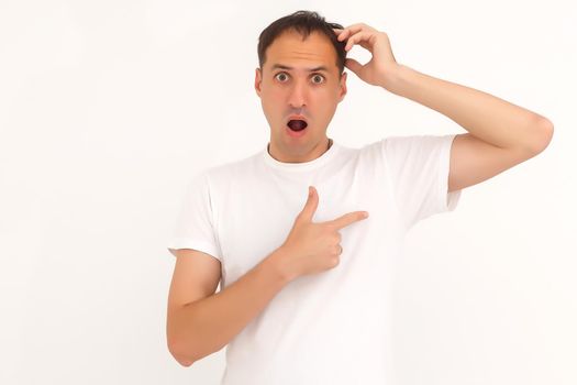 man shows a stain on his white t-shirt