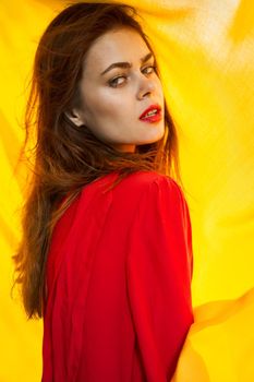 pretty woman in red dress nature yellow cloth on background. High quality photo