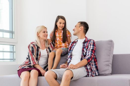 Smiling young parents and their child are very happy, they are at home