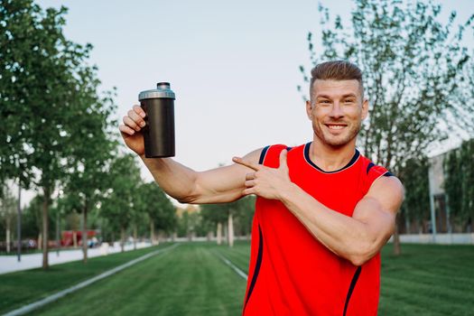 sporty man in the park outdoors glass with drink. High quality photo