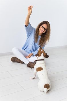 Pets owner - Attractive cheerful female in blue sweater playing with her favourite pet. Happy woman with her jack russell terrier