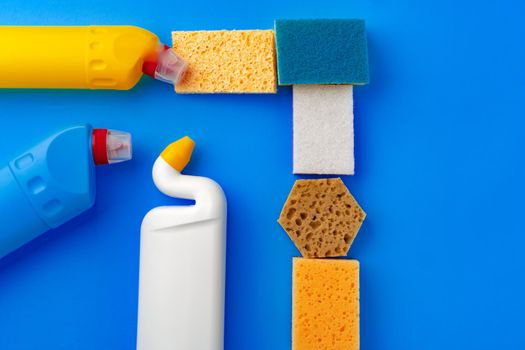 House cleaning supplies on blue color background, top view
