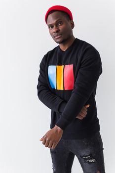 Studio shot of young handsome African man wearing hoodie against white background.