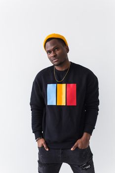 Portrait handsome young black man dressed in jeans and hoodie on white background. Street fashion and modern youth culture