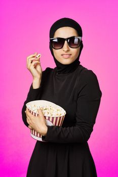 cheerful woman fun popcorn entertainment fashion purple background. High quality photo