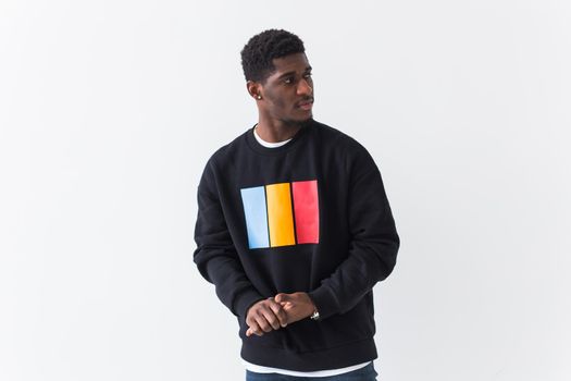 Portrait handsome young black man dressed in jeans and hoodie on white background. Street fashion and modern youth culture