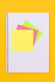 A Notepad with Sticky Notes Lying on Yellow Table - Blank Template. Top View, Flat Lay