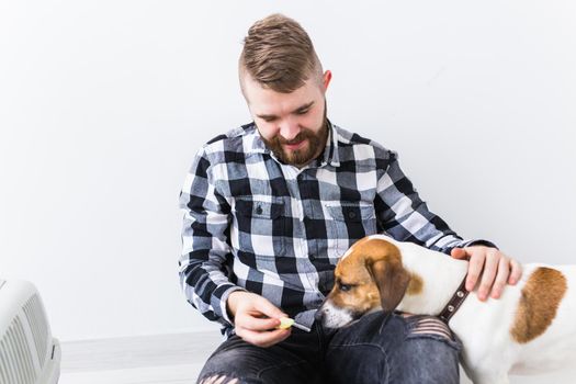 Dog carrying bags and pets owner concept - Attractive cheerful male in plaid shirt holds favourite pet. Happy bearded man with his jack russell terrier.