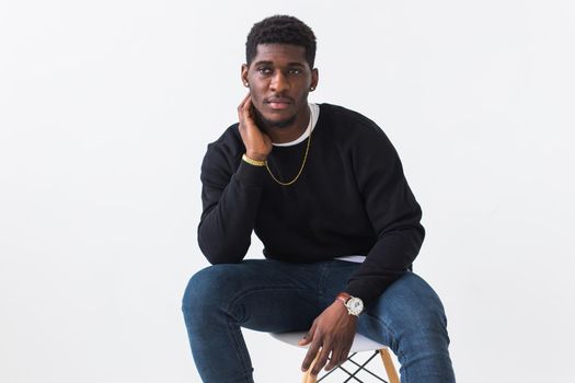 Handsome African American man posing in black hoodie on a white background. Youth street fashion photo with afro hairstyle
