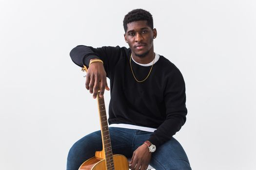 Studio shot of young handsome African man wearing hoodie against white background.