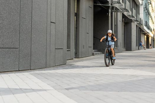 Adorable little girl riding a bike in a city