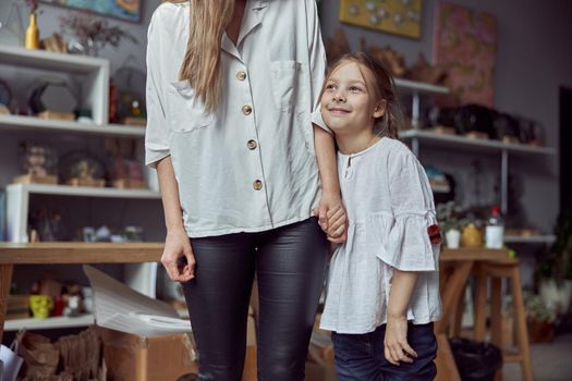 Happy caucasian mother with young beautiful cheerful daughter are having time together at the store