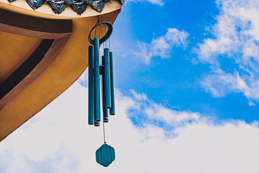E Pagoda curved roof building temple, metal big hanging wind sound bell chime effect melodious buddhism china. Day blue sky clouds background. Calm god religious peace quiet relax soul health mood.