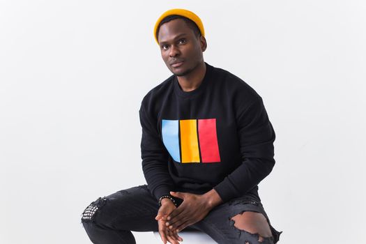 Handsome African American man posing in black hoodie on a white background. Youth street fashion photo with afro hairstyle