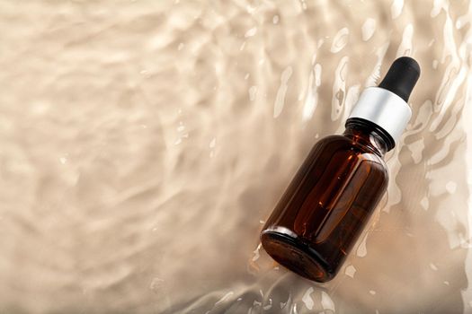 Cosmetic bottle with pipette in wavy water, top view