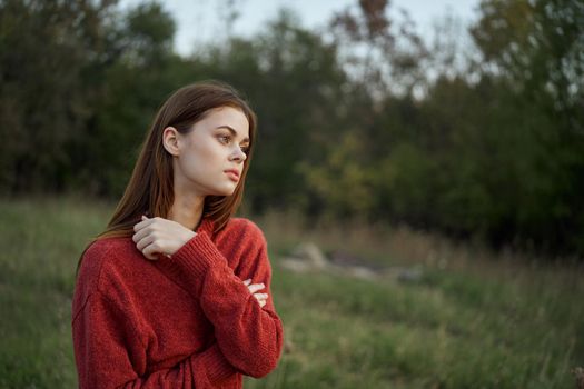woman in a red sweater outdoors in a field walk. High quality photo
