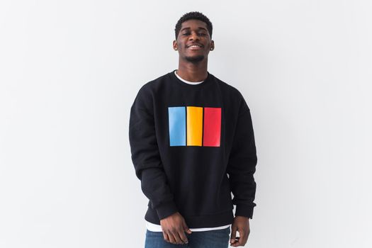 Portrait handsome young black man dressed in jeans and hoodie on white background. Street fashion and modern youth culture