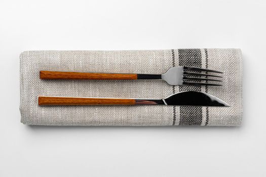Set of fork and knife on towel. Isolated on white background. Close up.