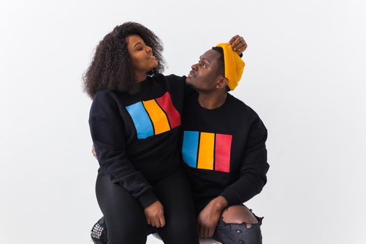 Happy African American woman and man have relationships, toothy smile, happy to meet with friends, dressed casually on white background. Emotions and friendship