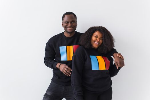 Happy African American woman and man have relationships, toothy smile, happy to meet with friends, dressed casually on white background. Emotions and friendship