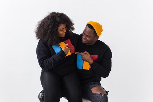 Happy African American woman and man have relationships, toothy smile, happy to meet with friends, dressed casually on white background. Emotions and friendship