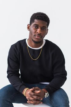 Handsome African American man posing in black hoodie on a white background. Youth street fashion photo with afro hairstyle