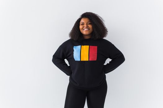 Beautiful African American woman posing in black hoodie on a white background. Fashion with afro hairstyle.