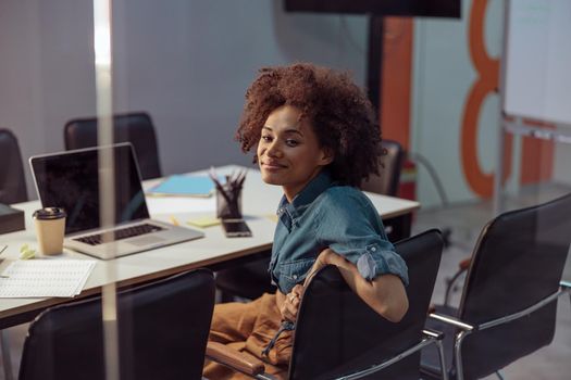 Happy Afro American employer sitting in meeting room and using laptop. Business, employment concept