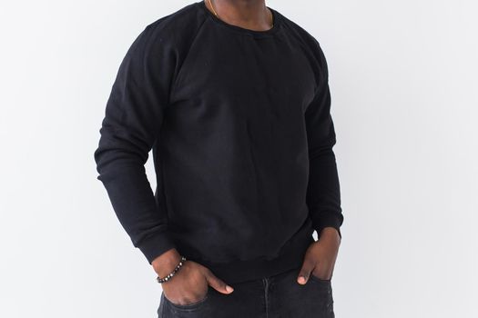 Portrait handsome young black man dressed in jeans and hoodie on white background. Street fashion and modern youth culture