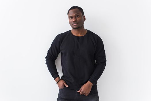 Portrait handsome young black man dressed in jeans and hoodie on white background. Street fashion and modern youth culture